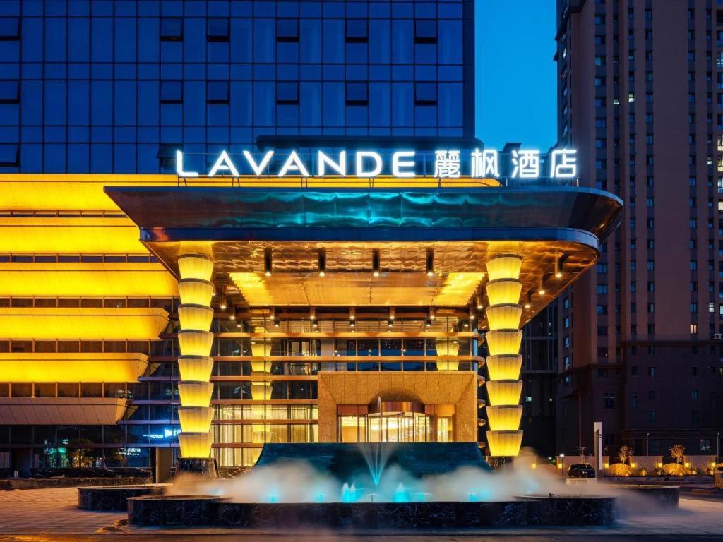 a large building with a sign on it at night at Lavande Hotel Anshan City Center in Anshan