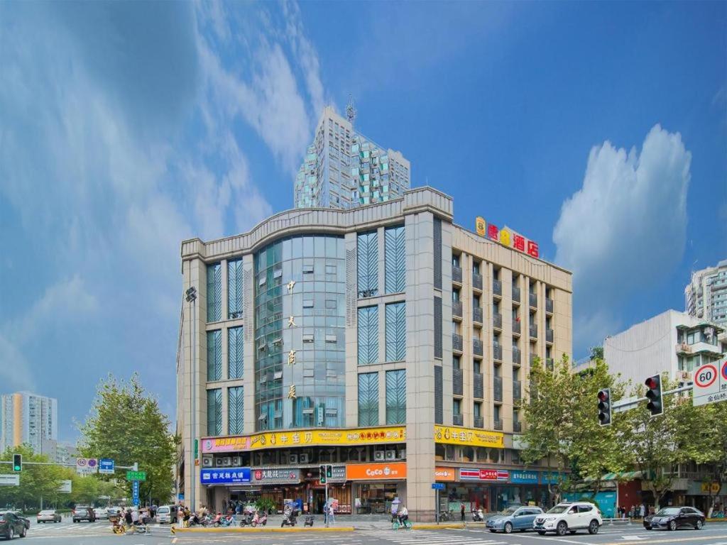 duży budynek przy ulicy miejskiej z światłem drogowym w obiekcie Super 8 Hotel Chengdu Kuan Zhai Zane Huapaifang w mieście Chengdu