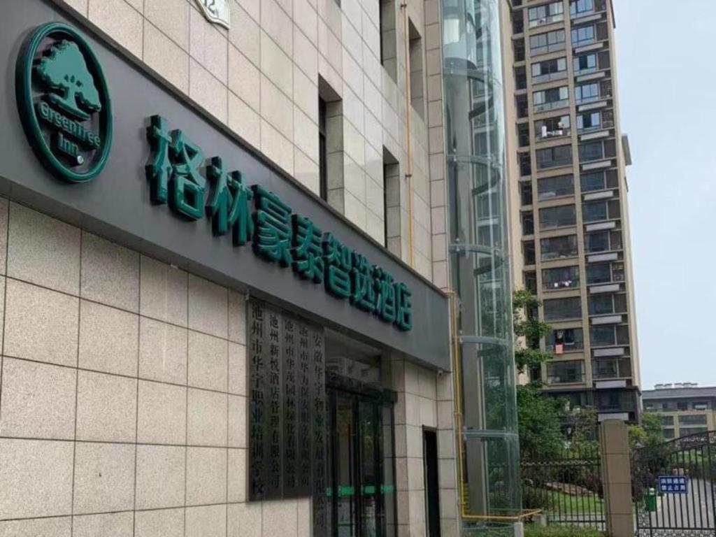 un edificio con un cartel en el costado en Green Tree Inn Express Chizhou Gymnasium, en Pai-sha-p'u