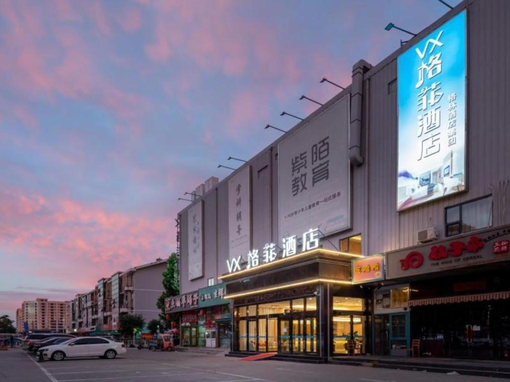 un edificio con un cartello sul lato di una strada di VX Hotel Beijing Daxing Wufutang Metro Station Zhongke Dianshanggu a Donggaodi