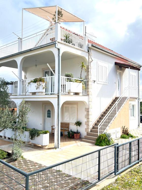 a white house with a balcony and stairs at Villa Oliva Korcula in Korčula