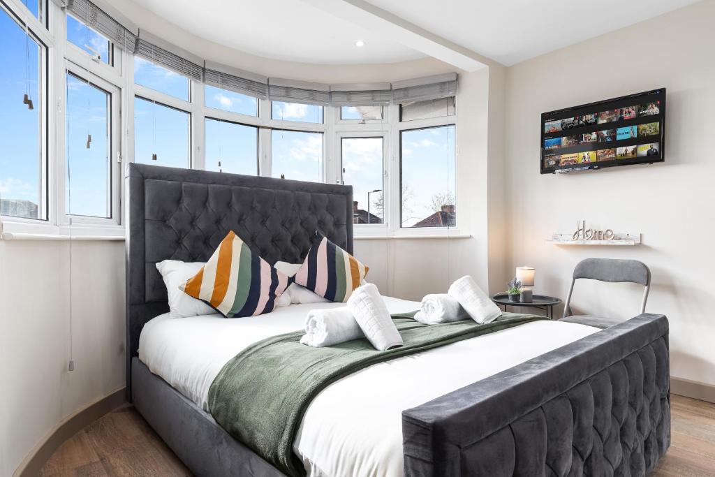 uma cama grande num quarto com janelas em Serviced Ensuite Modern Studio - Sleeps 2 - Near Wembley Stadium - Good Transport Link to Central London - Harrow HA3 em Hatch End