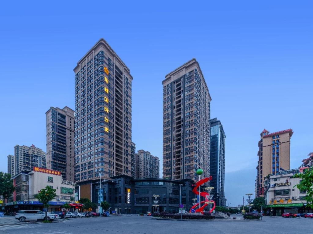 a city with tall buildings and a red sculpture at Poltton International Service Apartment Jieyang Qiaonan Yudu in Jieyang