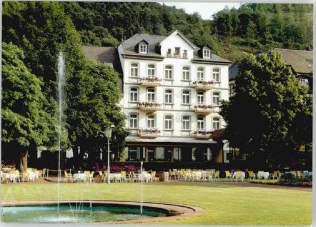 a large white building with a fountain in front of it at Vintagehotel Adler in Bad Bertrich