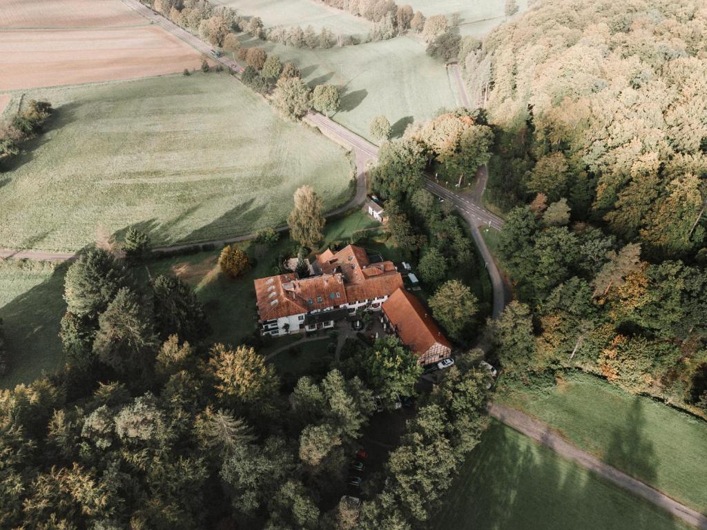 eine Luftansicht eines Hauses in der Mitte eines Feldes in der Unterkunft Landhotel Waldhaus in Laubach