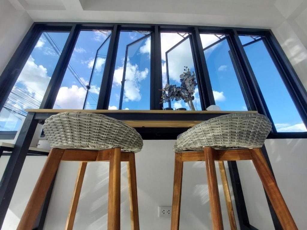dos sillas sentadas en una mesa frente a una ventana en A Day Hotel en Roi Et