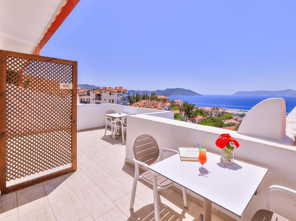 a balcony with a table and chairs and the ocean at Yoga House Kaş in Kas