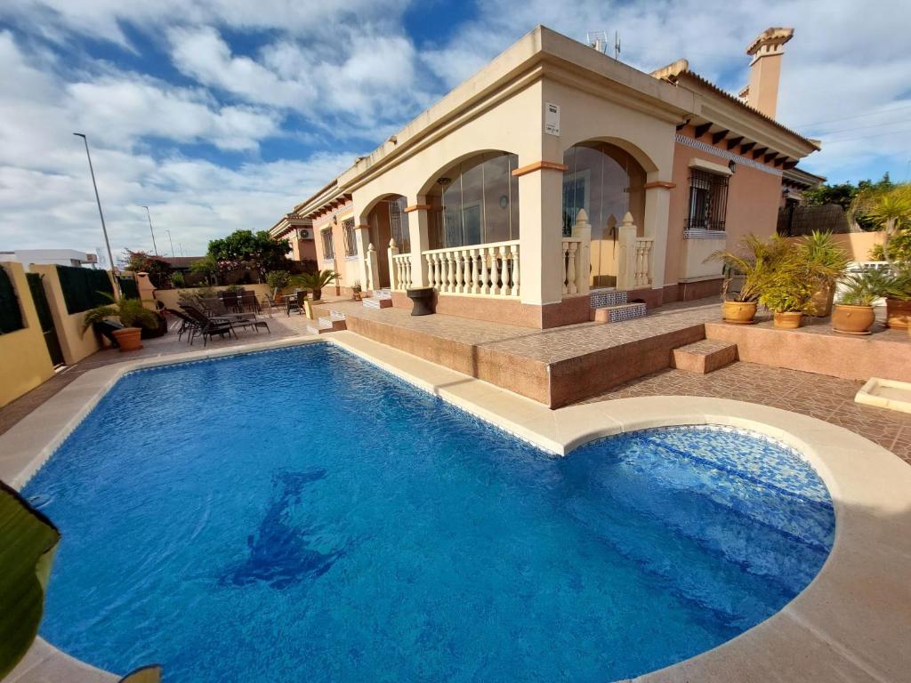 a swimming pool in front of a house at Villa Christophe in Alicante