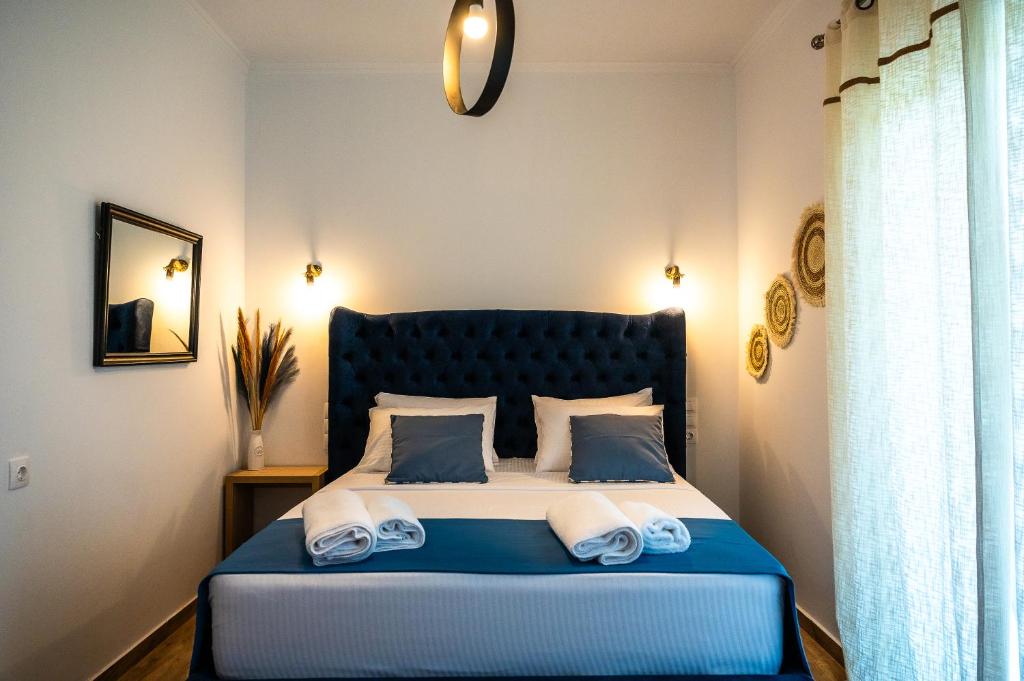 a bedroom with a bed with two towels on it at Margo Cozy Houses in Mavrovouni