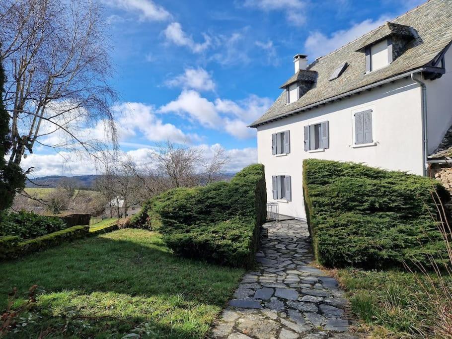 une maison blanche avec un chemin en pierre à côté dans l'établissement La Maison de famille, à Le Nayrac