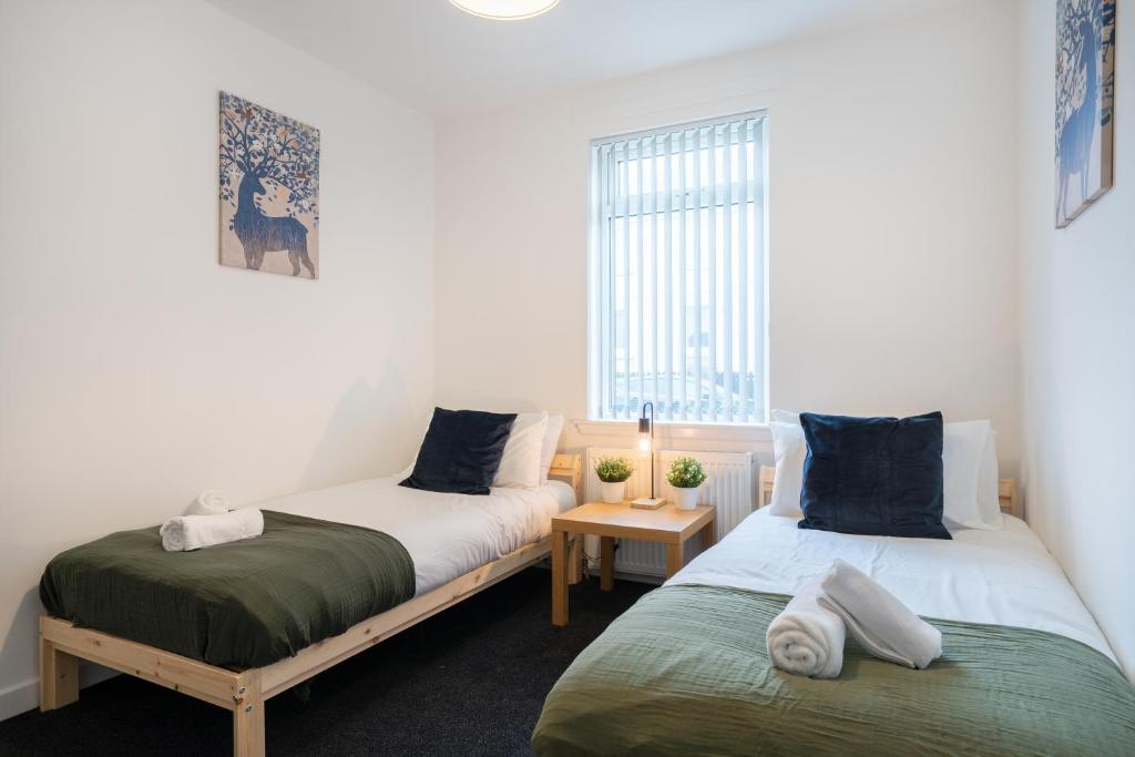 a bedroom with two beds and a window at 2 Bedroom Apartment-Free Parking in Wishaw