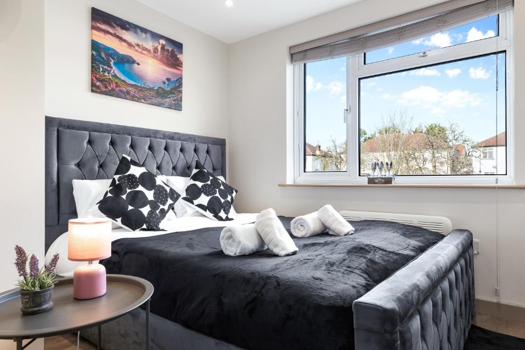 a bedroom with a large bed and a window at Charming Serviced Ensuite Modern Studio - Sleeps 2 - Near Wembley Stadium - Good Transport Link to Central London - Harrow HA3 in Hatch End