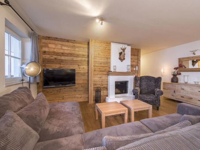 a living room with a couch and a fireplace at Apartment Alpenresort Saalbach E2 in Saalbach-Hinterglemm