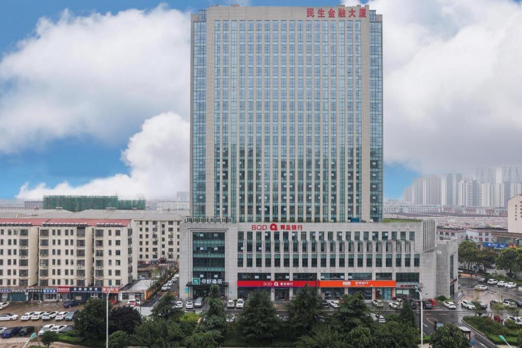 a tall building in a city with cars at NIHAO Hotel Linyi Jiefang East Road Financial Building in Linyi