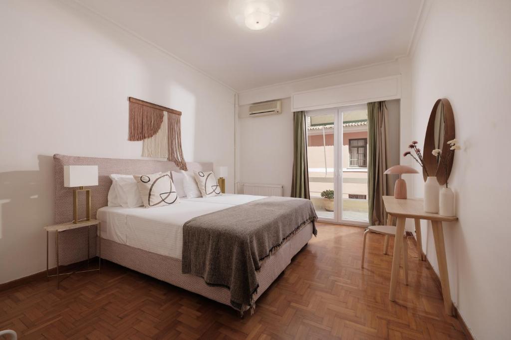 a bedroom with a large bed and a window at Zampeli Apartment in Corfu