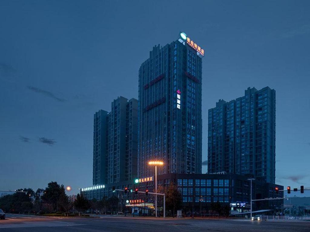 ein hohes Gebäude mit einem Schild oben drauf in der Unterkunft Vienna Hotel Yueyang East Station in Yueyang