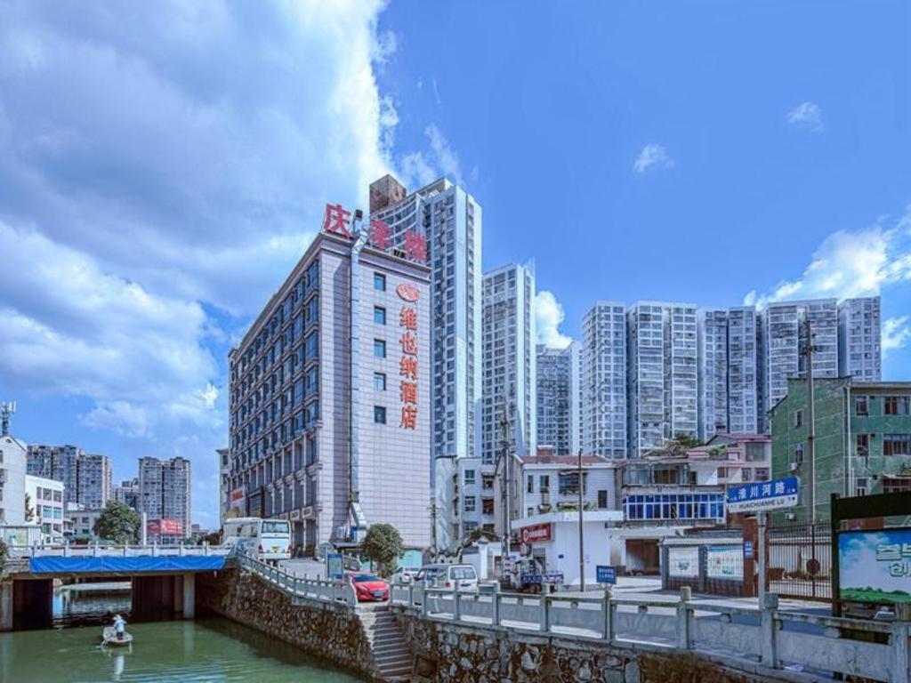 a city with tall buildings and a body of water at Vienna Hotel Hunan Liuyanghe Daqiao in Liuyang