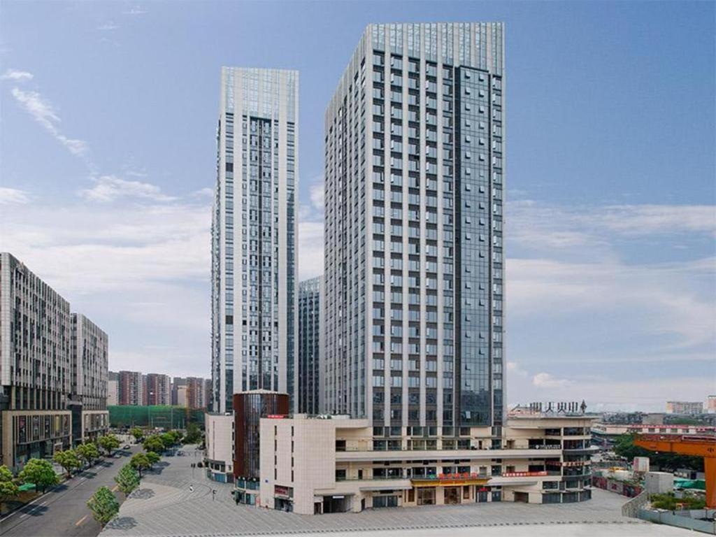 dois arranha-céus altos numa cidade com edifícios em Vienna Hotel Chengdu North Railway Station North Square Wukuaishi Metro Station em Chengdu