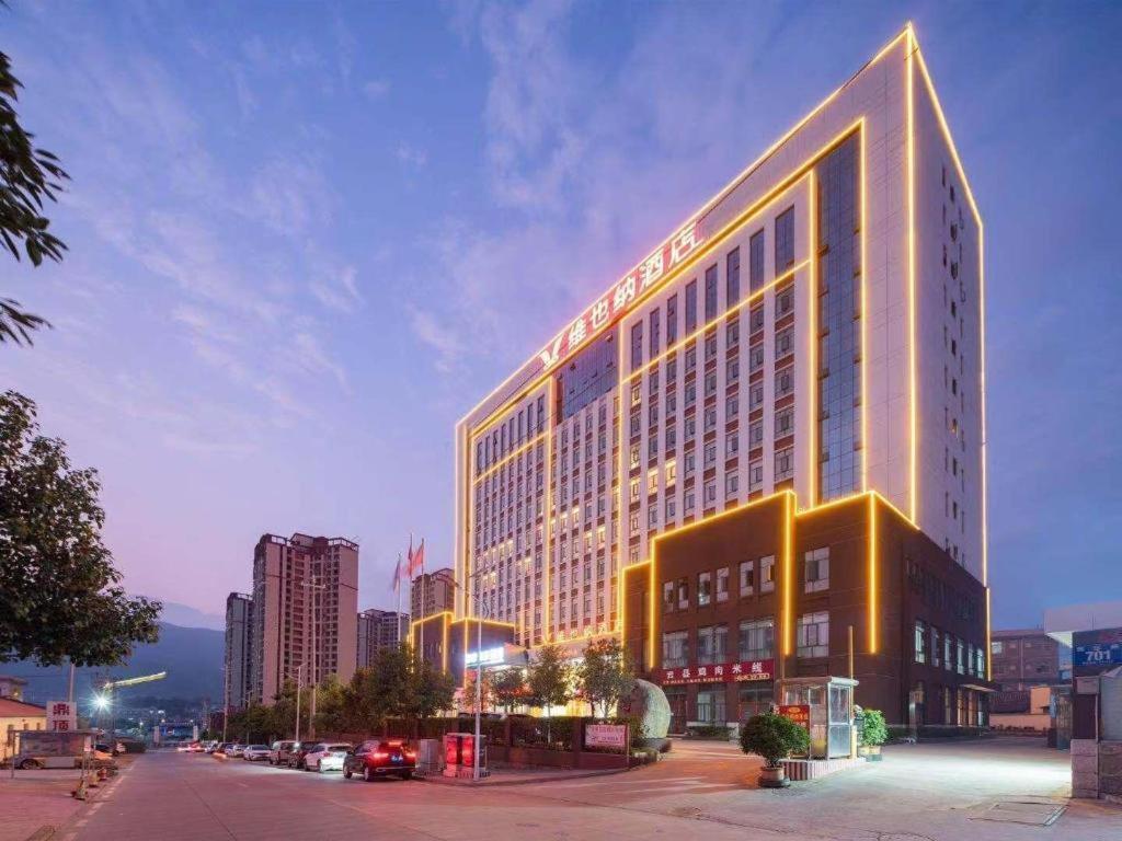 ein beleuchtetes Gebäude in der Nacht auf einer Stadtstraße in der Unterkunft Vienna Hotel Lincang New Asia Pacific Times Square in Lincang