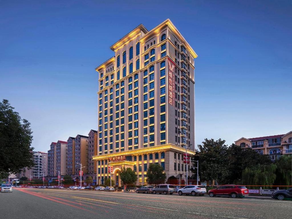 a tall building on the side of a city street at Vienna Hotel Henan Xinyang East Zone of Central Hospital in Pingqiao