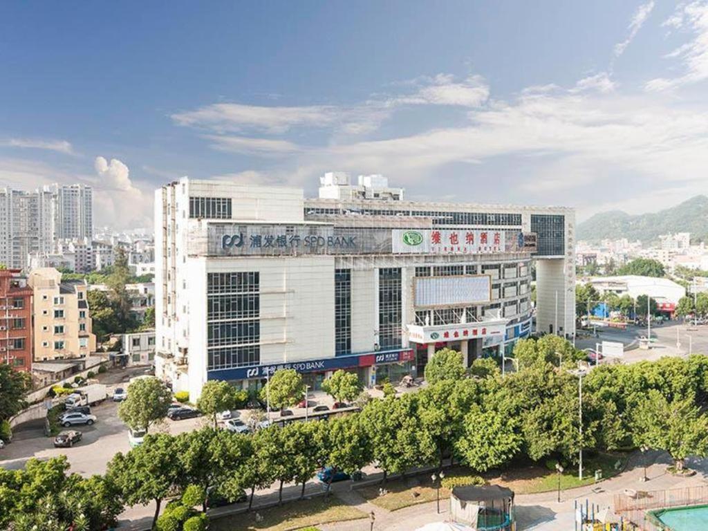 duży biały budynek w środku miasta w obiekcie Vienna Hotel Fuzhou Changle Zhenghe Metro Station w mieście Changle