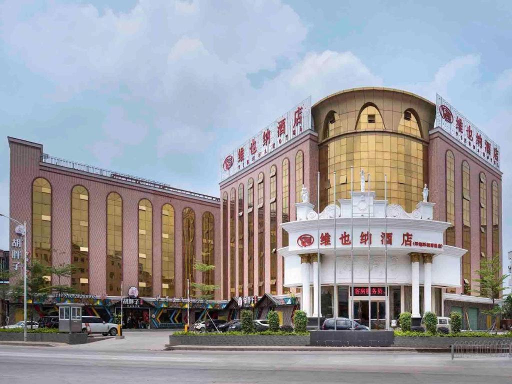 een groot bruin gebouw met een witte koepel bij Vienna Hotel Shenzhen Pingdi Huancheng South Road in Longgang