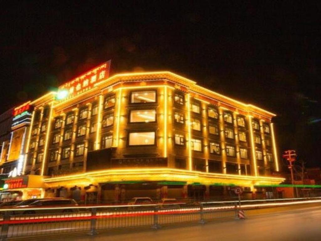 a large building with lights on it at night at Vienna Hotel Qinghai Yushu Tangfan Avenue in Chumda