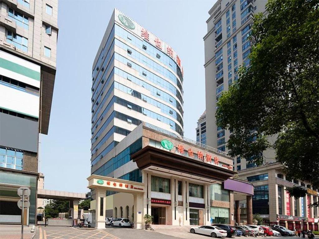 a large building with a sign on it in a city at Vienna Hotel Hunan Chenzhou Municipal Government in Chenzhou