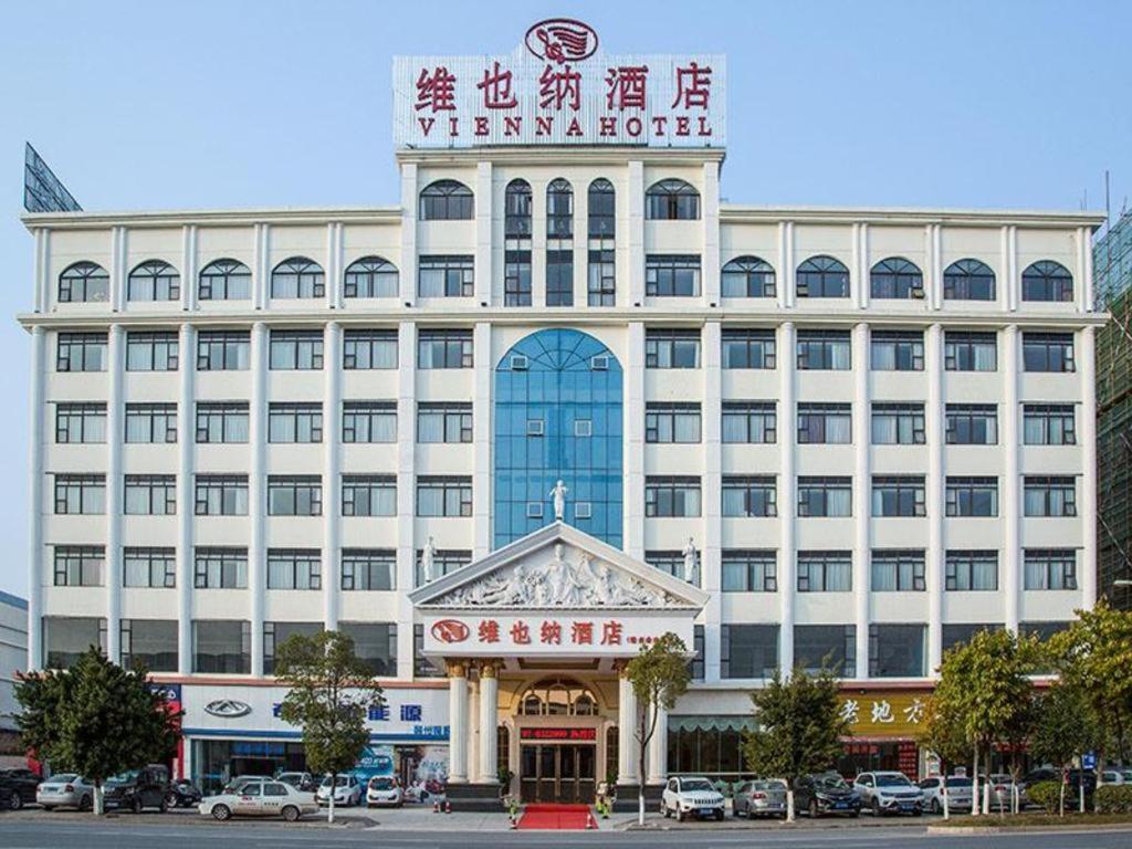 a large white building with a sign on top of it at Vienna Hotel Ganzhou Economic Development Zone 1st Hospital West High-Speed Railway Station in Ganzhou