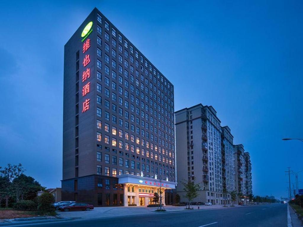 un grand bâtiment avec un panneau sur son côté dans l'établissement Vienna Hotel Zhejiang Jinhua Jinyuhuayuan, à Chengnan