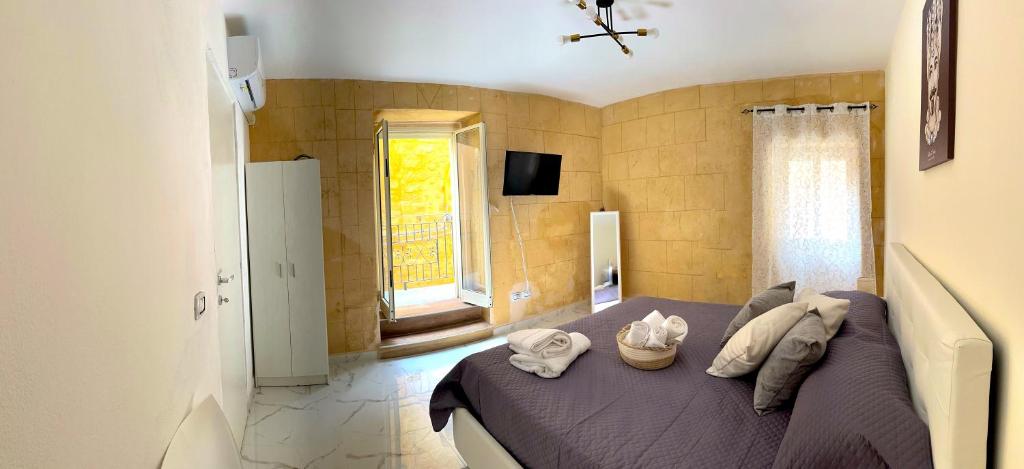 1 dormitorio con 1 cama con toallas en L’Angolo Degli Dei en Agrigento