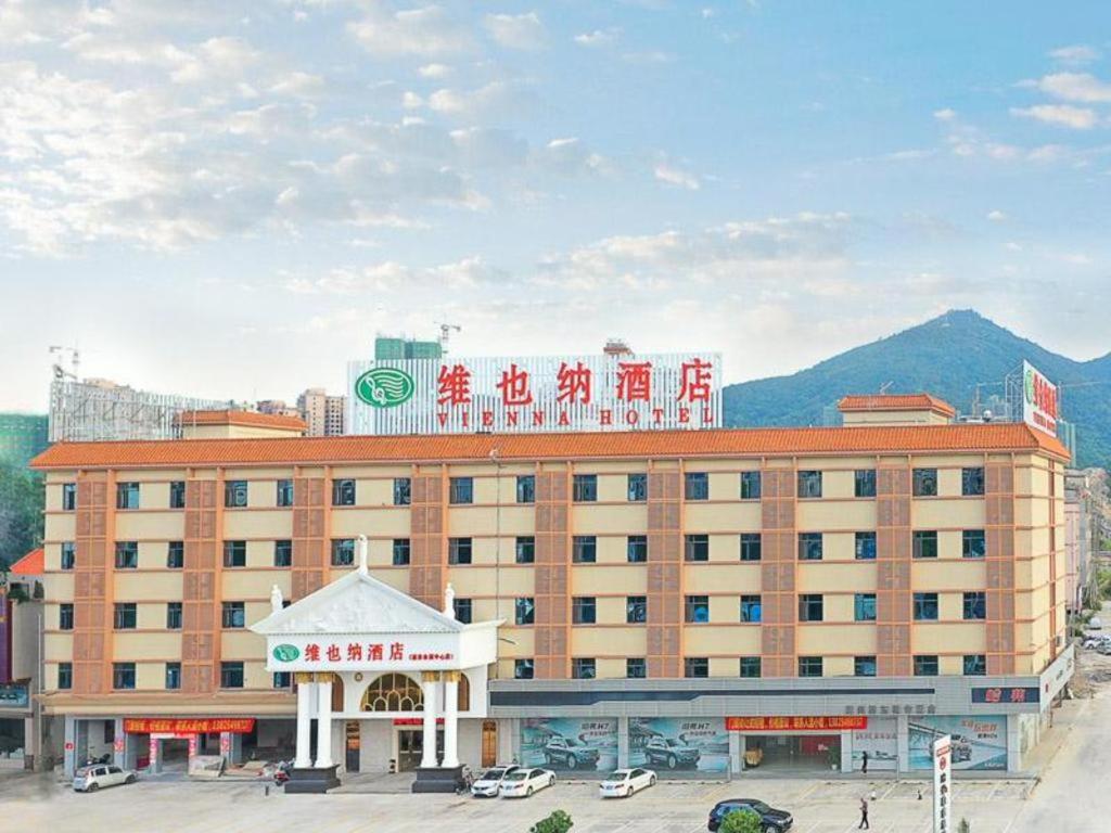 un grande edificio con un cartello sopra di Vienna Hotel Guangdong Huidong Exhibition Center a Huidong