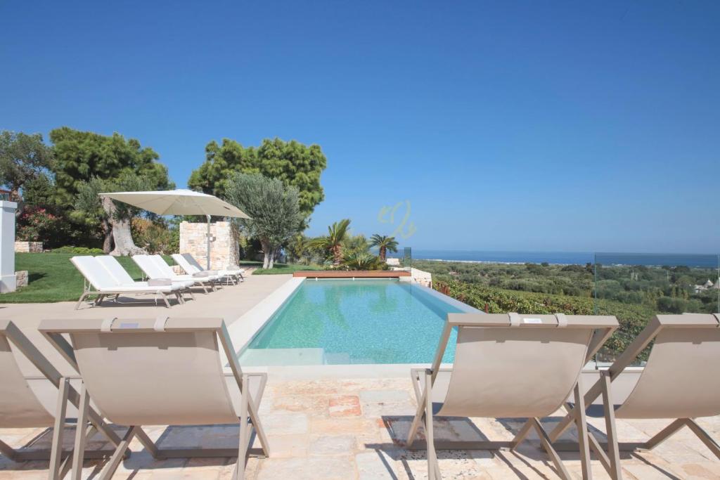 une villa avec piscine et chaises longues dans l'établissement TD Casale Donna Madia Sea View Pool Over Vineyard, à Monopoli