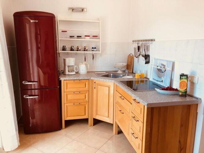 a kitchen with a red refrigerator and a sink at Holiday apartment 2 in Casa-Viter in Zaostrog