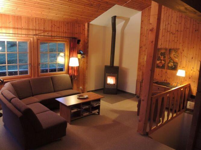 a living room with a couch and a stove at Chalet Wachsmuth in Wiler