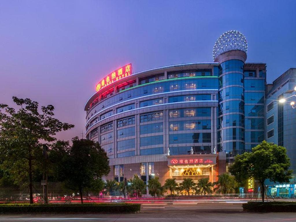 a large building with a sign on top of it at Vienna Hotel Guangdong Jiangmen Yingbin Avenue in Jiangmen