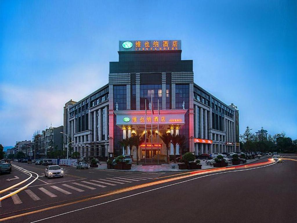 un grand bâtiment avec une tour d'horloge en haut dans l'établissement Vienna Hotel Hunan Yueyang Linxiang, à Linxiang