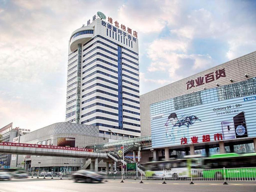 ein großes Gebäude mit einem Schild an der Seite in der Unterkunft Vienna Hotel Hebei Qinhuangdao Hebei Street Taiyangcheng in Qinhuangdao