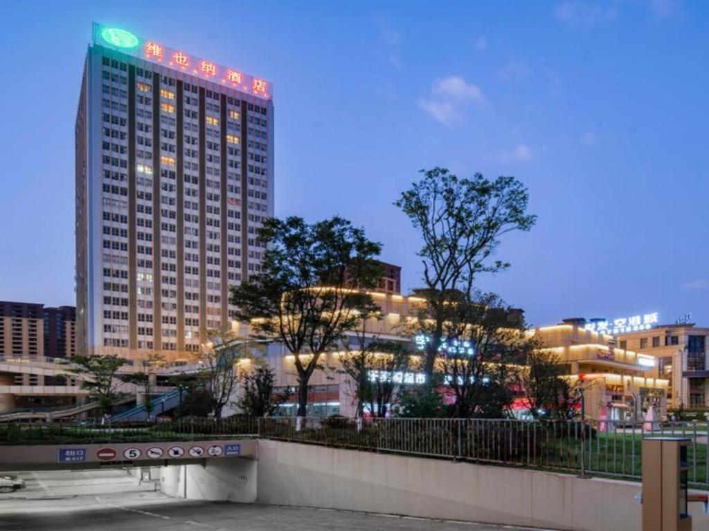 a tall building with lights on it in a city at Vienna Hotel Kunming Dianzhong New District in Yanglin