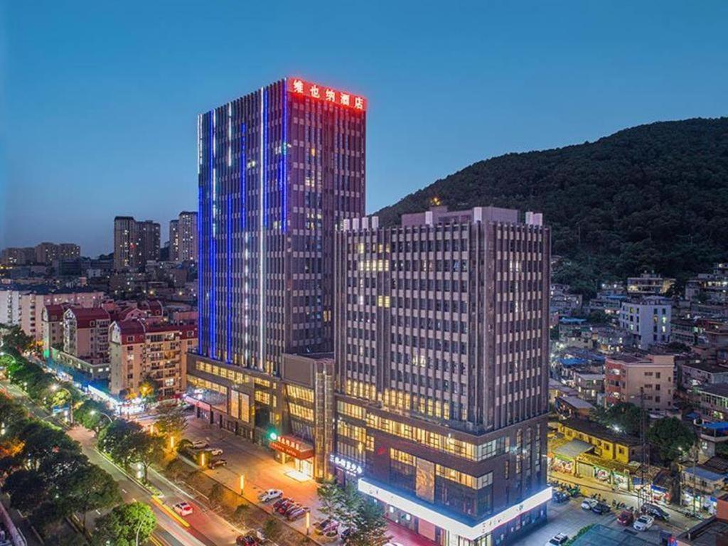 ein hohes Gebäude mit Lichtern in einer Stadt in der Unterkunft Vienna Hotel Fuzhou Mawei in Mawei