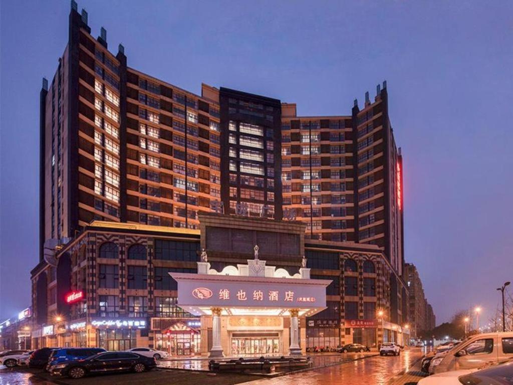 a large building with a sign in front of it at Vienna Hotel Jiangsu Kunshan Changjiang North Road Fenghuangcheng in Kunshan