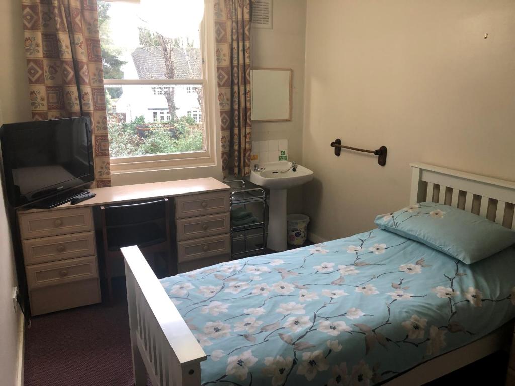Dormitorio con cama, escritorio y TV en St James's House en Londres