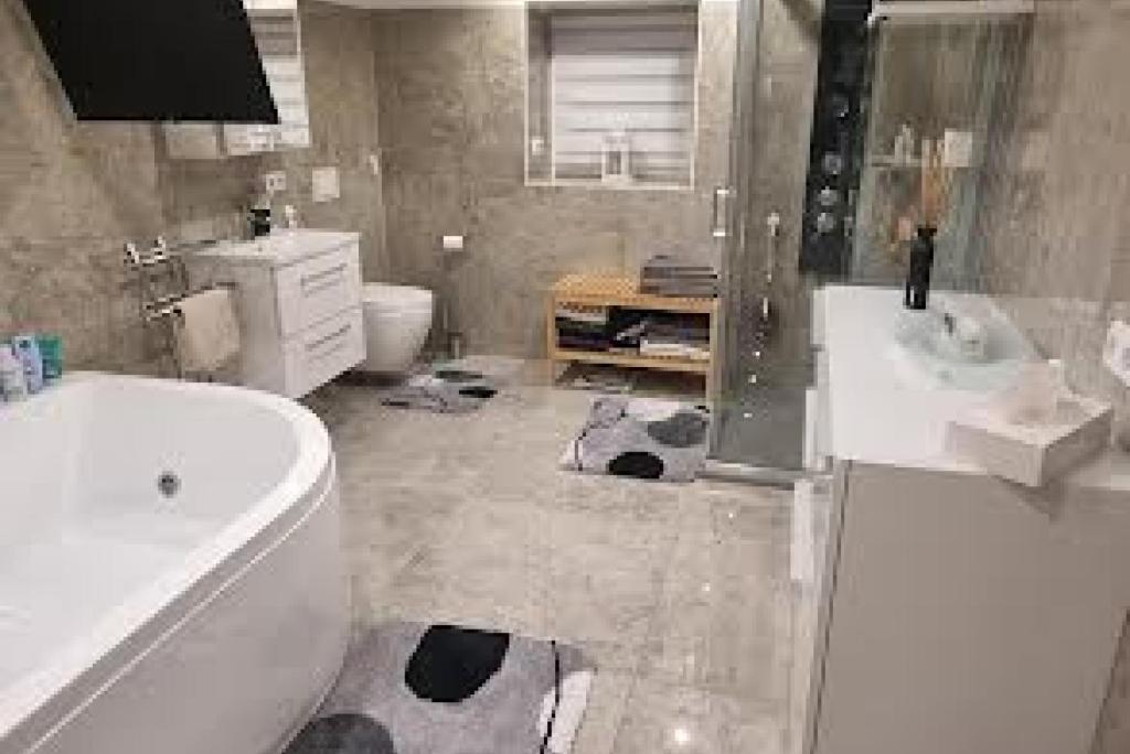 a bathroom with a sink and a tub and a toilet at Private Apartment in Ronnenberg