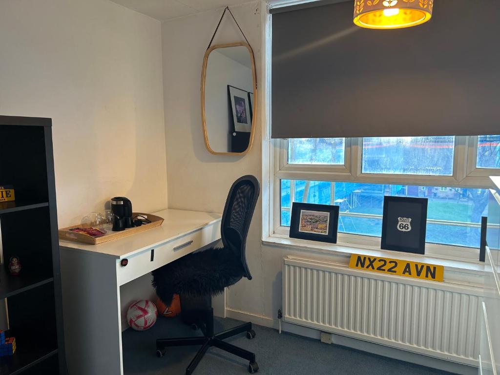 a desk and a chair in a room with a window at Hermitage Court in London