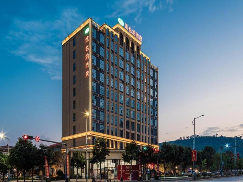 wysoki budynek z znakiem na górze w obiekcie Vienna Hotel Kunming Yiliang Xingyue Building w mieście Yiliang