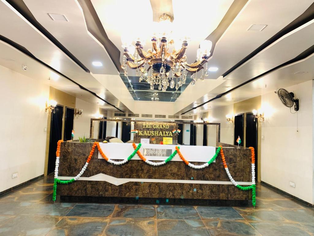 a banquet hall with a table with a chandelier at Hotel Grand Kaushalya in Sohāgpur