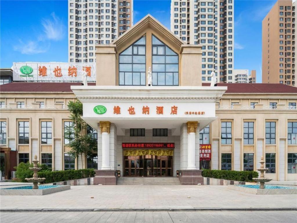 a building in a city with tall buildings at Vienna Hotel Tianjin Zhongbei Town in Caozhuang