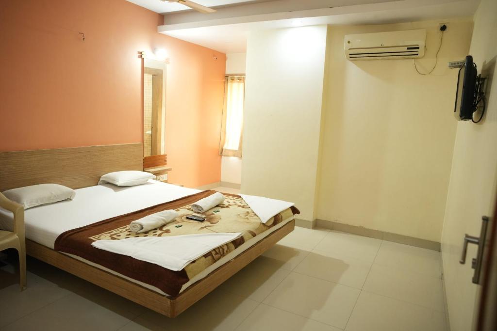 Postel nebo postele na pokoji v ubytování HOTEL SAI SURYA