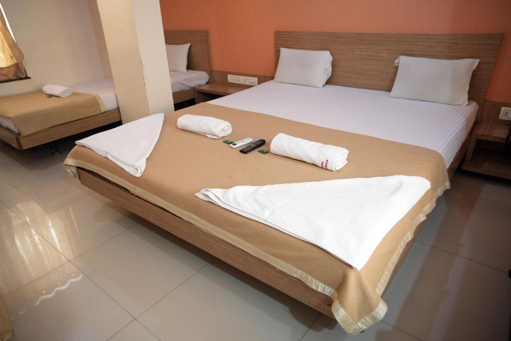 Postel nebo postele na pokoji v ubytování HOTEL SAI SURYA