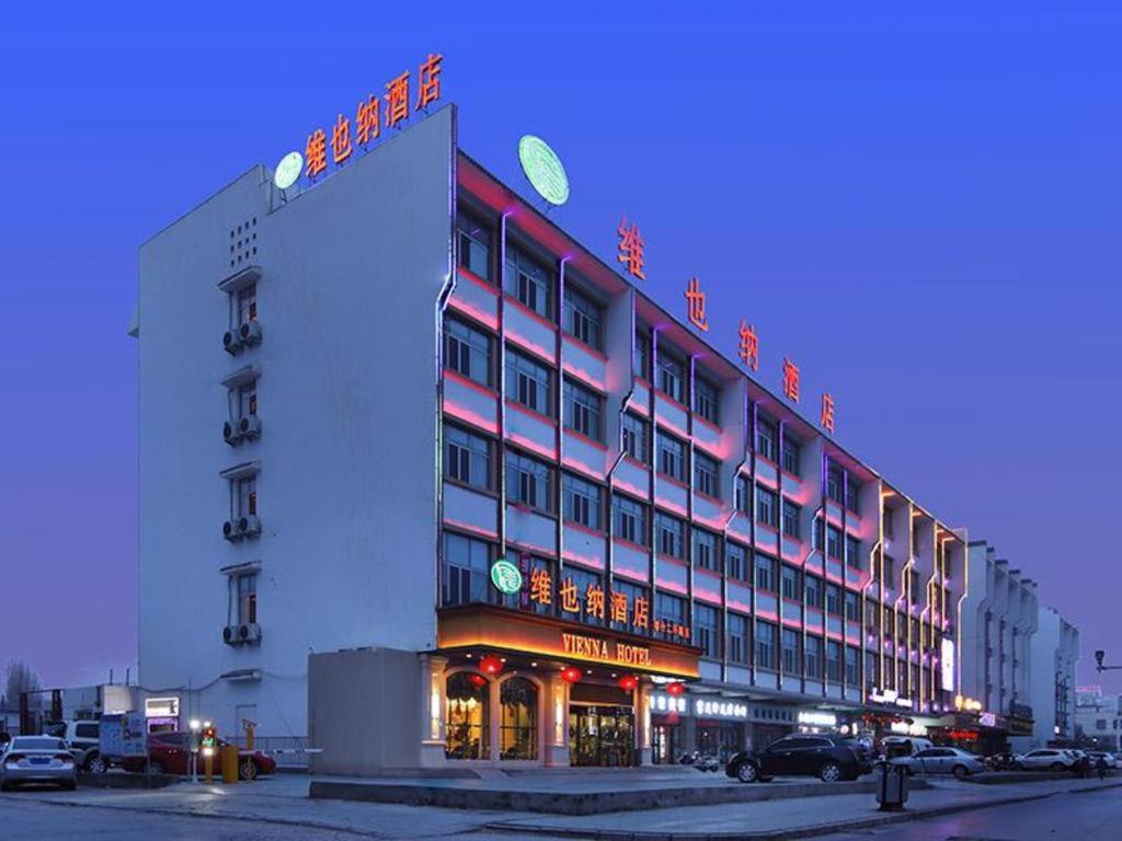 ein Gebäude mit einem Schild an der Seite in der Unterkunft Vienna Hotel Xinjiang Kashgar 2nd Ring Road Food Street in Kashgar